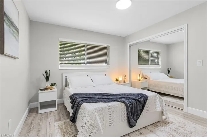 Wood-finish flooring, recessed lighting, window with blinds, and mirrored closet doors
