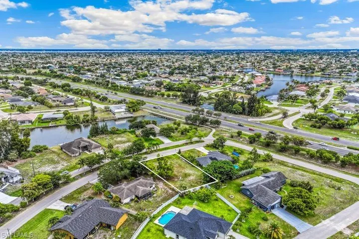 Expansive residential lot outlined in white, featuring surrounding established homes.