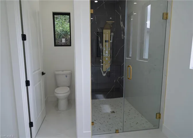 Bathroom featuring a marble finish shower and marble finish flooring