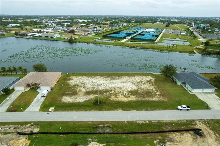 Aerial perspective of suburban area featuring a nearby body of water