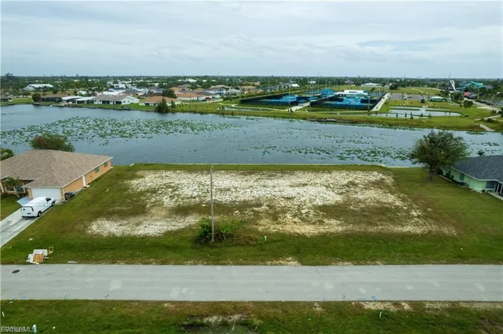 Aerial perspective of suburban area featuring a nearby body of water