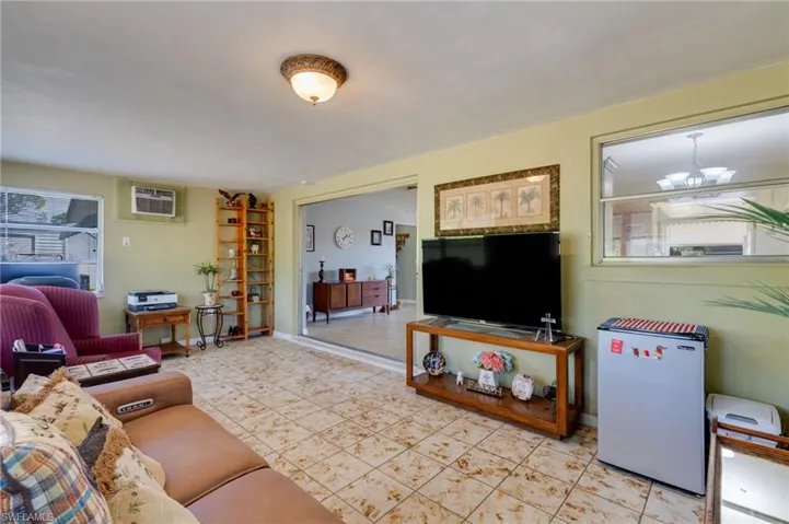 Living room featuring a wall mounted air conditioner and a chandelier