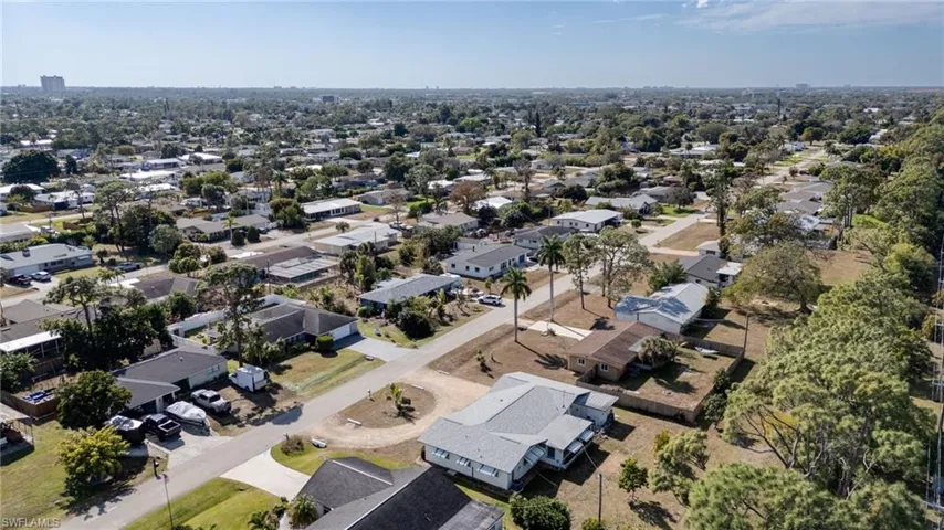 Aerial view of property and surrounding area featuring nearby suburban area