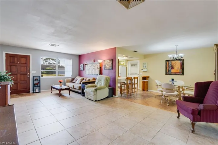 Living area with light tile patterned floors and a chandelier