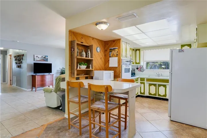 Dining area featuring light tile patterned flooring and wood walls