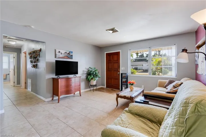 Living area featuring light tile patterned floors and baseboards