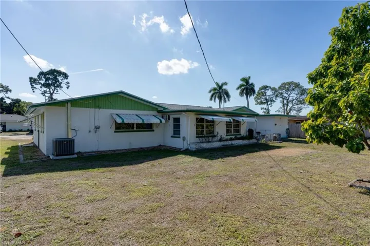 Rear view of property with a yard