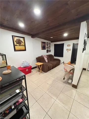 Living area featuring stained wood-plank ceiling, recessed lighting, and tile flooring