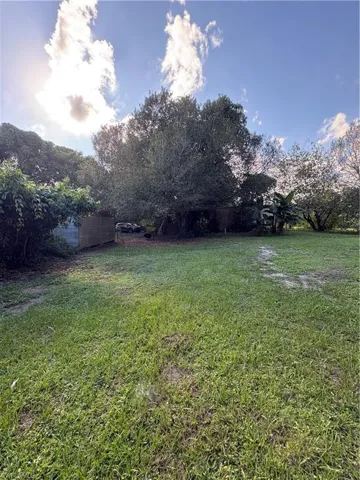 Expansive lot featuring mature trees, established greenery, and perimeter fencing