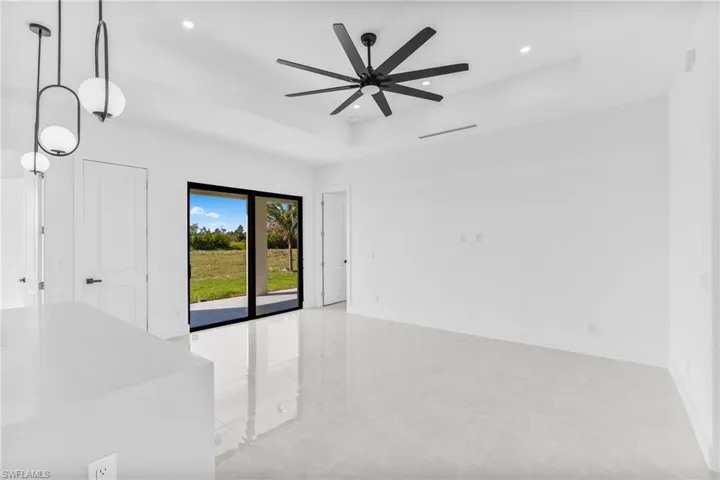 Unfurnished room featuring a tray ceiling, recessed lighting, and a ceiling fan