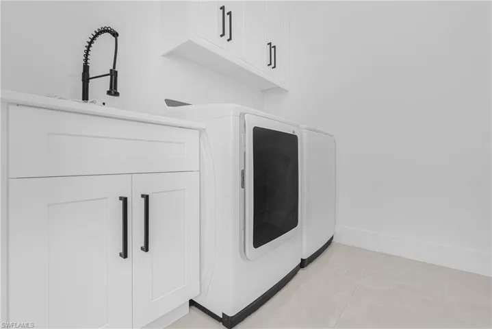 Laundry view of baseboards and independent washer and dryer