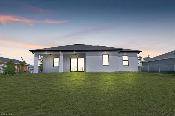 Rear view of house with a ceiling fan, stucco siding, and a patio area
