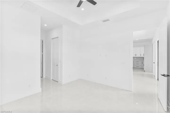 Empty room with recessed lighting, a raised ceiling, and a ceiling fan
