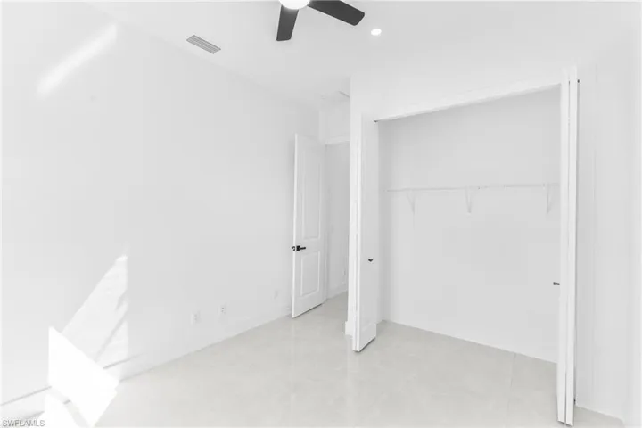 Unfurnished bedroom featuring a closet, a ceiling fan, recessed lighting, and light tile patterned flooring
