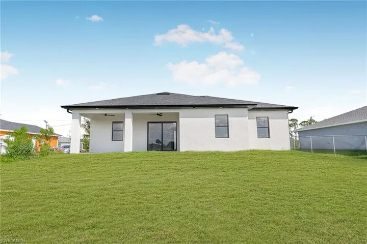 Back of property featuring stucco siding, a patio, a ceiling fan, and roof with shingles