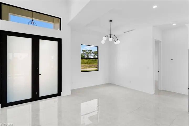 Spare room with a chandelier, recessed lighting, and light tile patterned floors