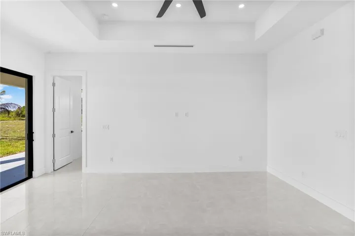Spare room with a ceiling fan, recessed lighting, and a tray ceiling