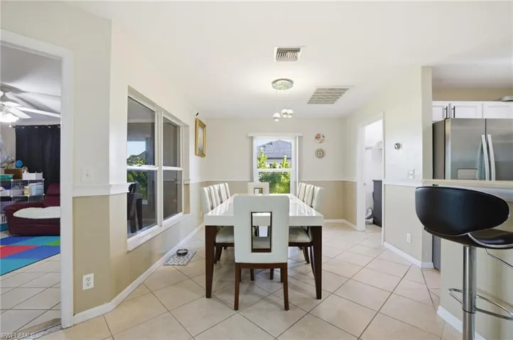 Dining area with light tile patterned flooring and a ceiling fan