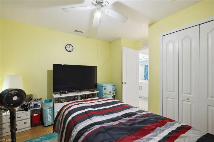 Bedroom with light wood-style floors, a ceiling fan, and a closet