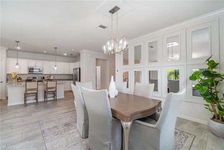 Dining area with a chandelier, recessed lighting, and ornamental molding
