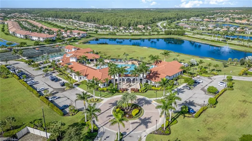 Aerial perspective of suburban area featuring a large body of water and a heavily wooded area