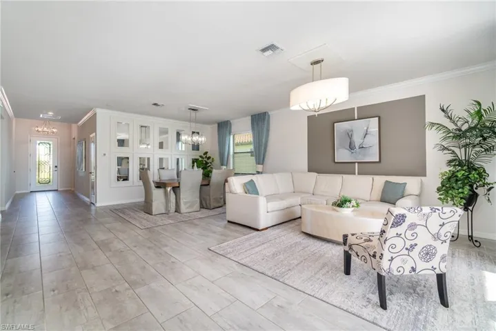 Living area featuring a chandelier and crown molding