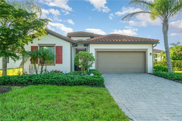 Mediterranean / spanish-style house featuring decorative driveway, a garage, a front lawn, and a tiled roof