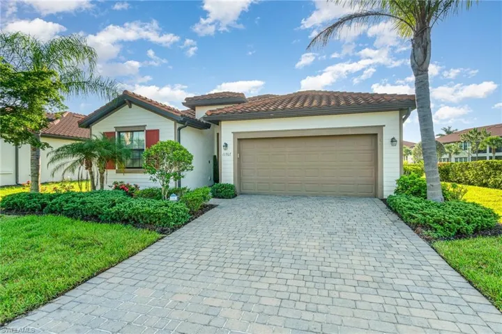 Mediterranean / spanish-style home with decorative driveway, an attached garage, a tiled roof, and stucco siding
