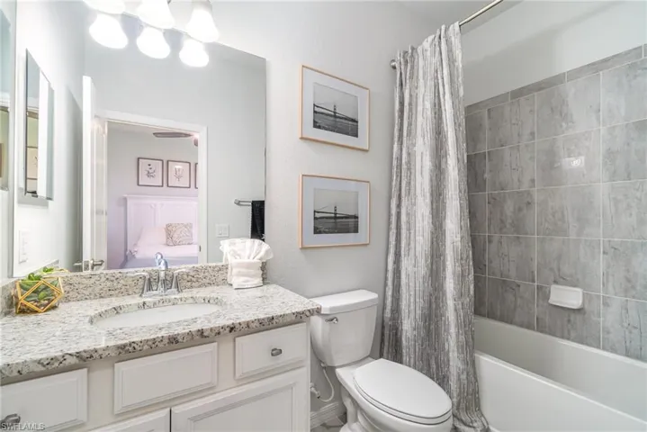 Full bathroom featuring vanity, shower / bath combo with shower curtain, and ensuite bath
