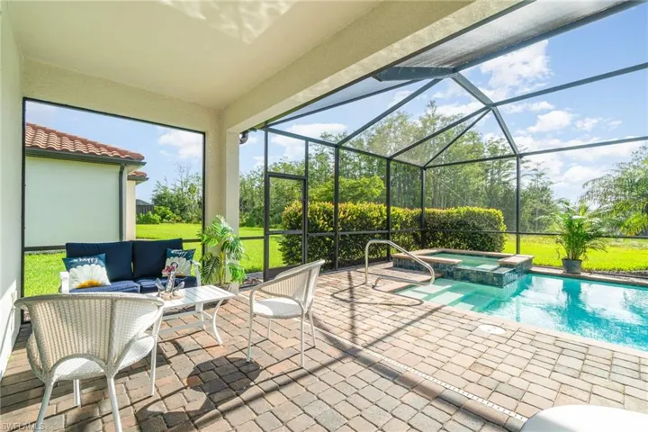 View of pool with a patio, outdoor lounge area, a pool with connected hot tub, and a lanai
