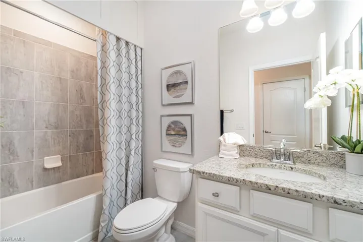 Bathroom with vanity and shower / bath combination with curtain