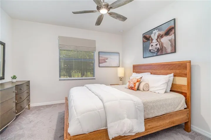 Carpeted bedroom featuring baseboards and a ceiling fan