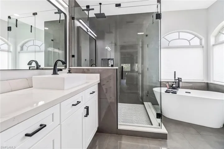Bathroom with independent shower and bath, vanity, and tile patterned flooring