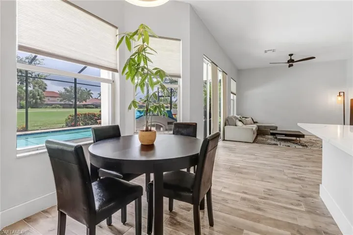 Dining room with a healthy amount of sunlight, ceiling fan, vaulted ceiling, and light hardwood / wood-style floors