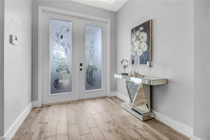 Foyer with light hardwood / wood-style floors and french doors