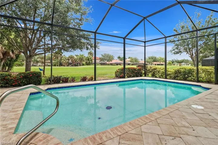 View of pool featuring a yard and glass enclosure