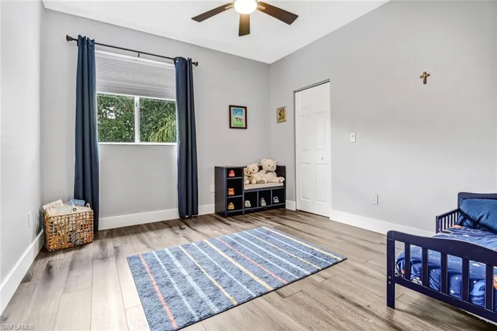Bedroom with ceiling fan and hardwood / wood-style floors