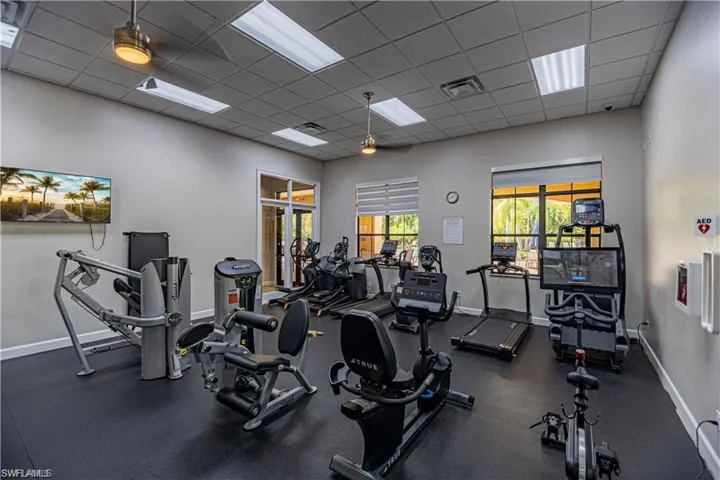 Workout area with ceiling fan and a drop ceiling