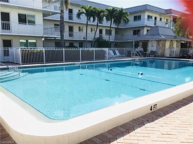 Pool area has plenty of seating tables, and lounge chairs