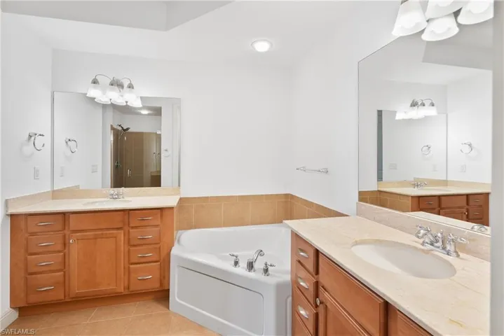 Bathroom featuring vanity, separate shower and tub, and tile patterned flooring