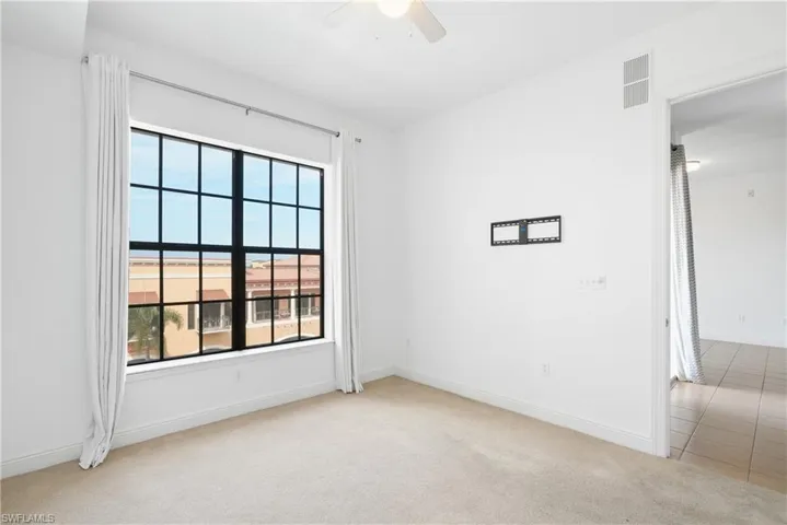 Spare room featuring ceiling fan and light colored carpet