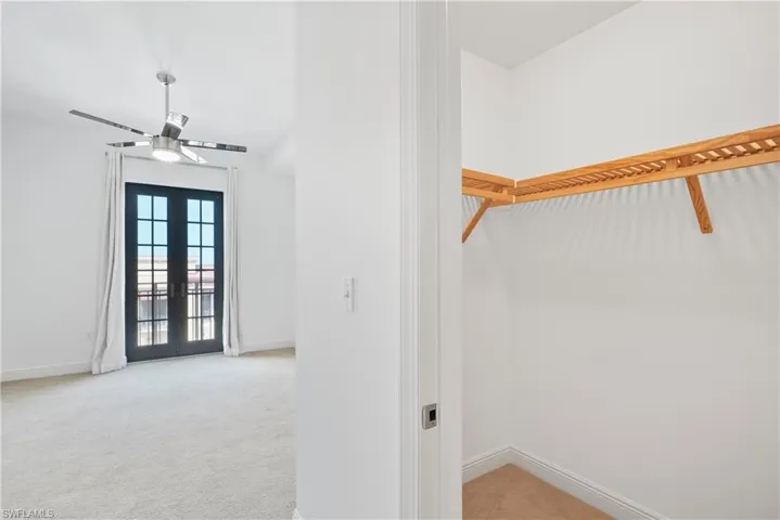 Spacious closet with french doors and light carpet