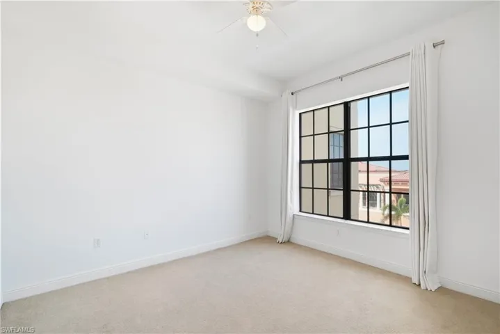 Carpeted spare room with ceiling fan