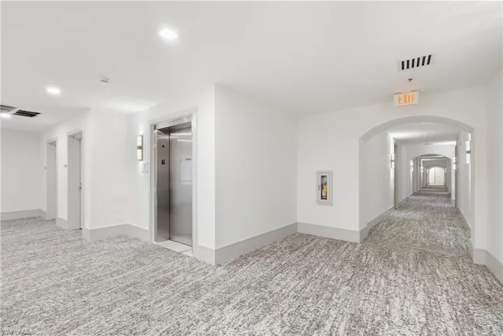 Hall featuring light colored carpet and elevator