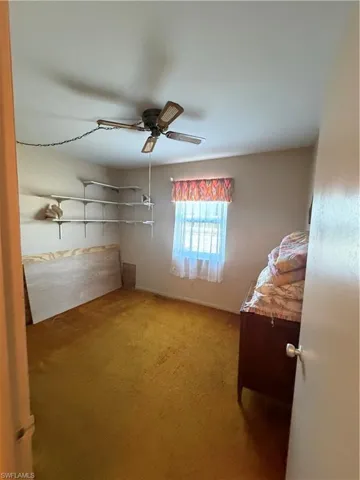 Unfurnished bedroom featuring a ceiling fan and light colored carpet
