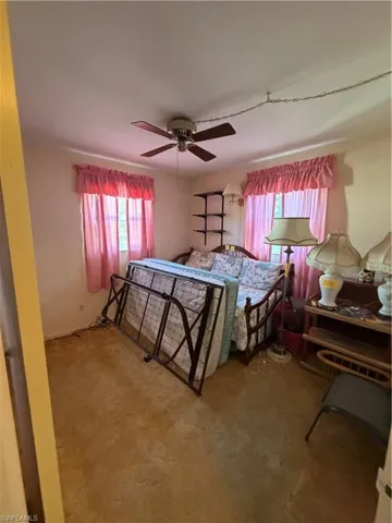 Bedroom with a ceiling fan and light carpet