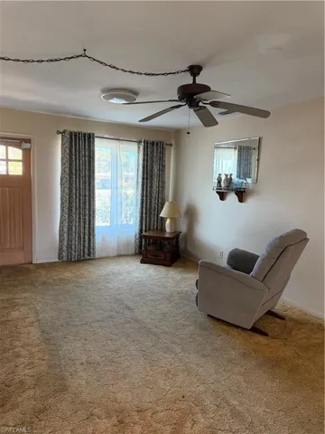 Sitting room with carpet and a ceiling fan