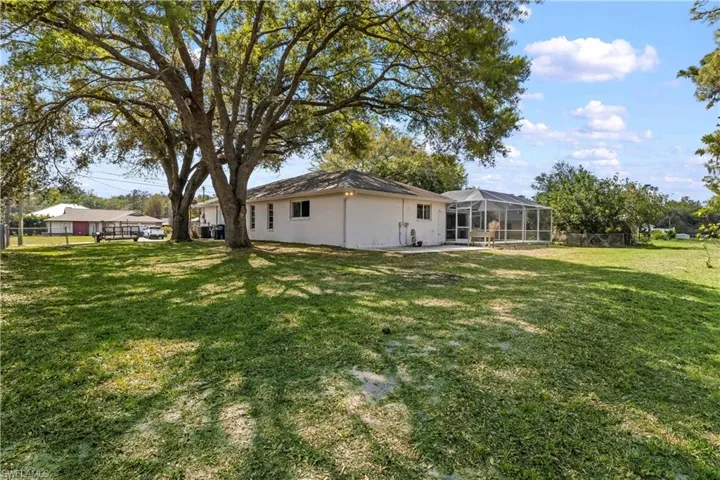 View of yard featuring glass enclosure and fence
