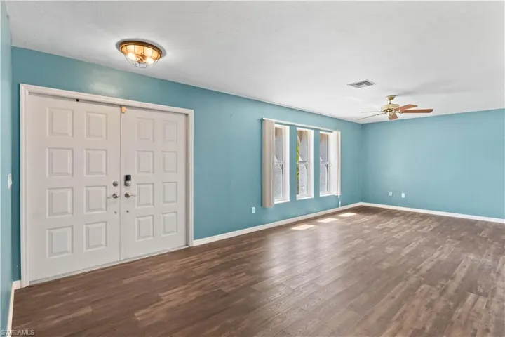 Entrance foyer featuring a ceiling fan, visible vents, baseboards, and wood finished floors