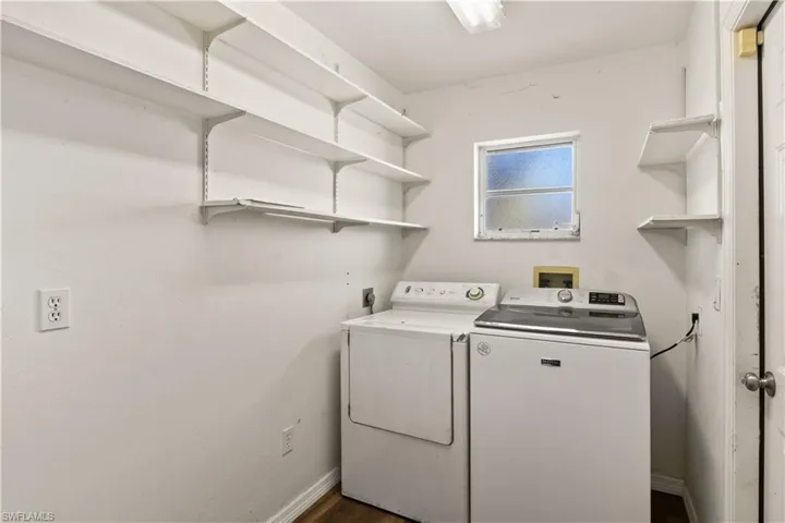 Laundry room with laundry area, baseboards, and separate washer and dryer
